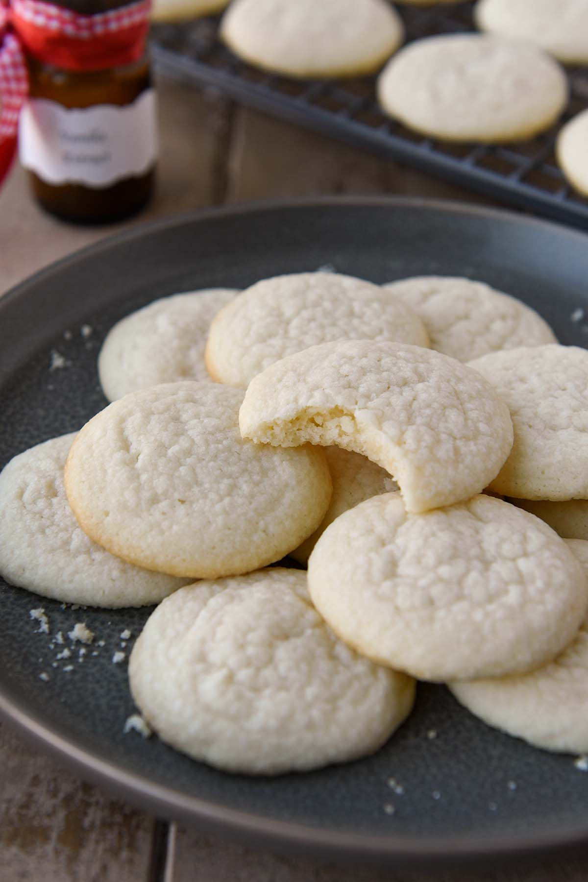 A plate of meltaway cookies with the top one missing a bite.