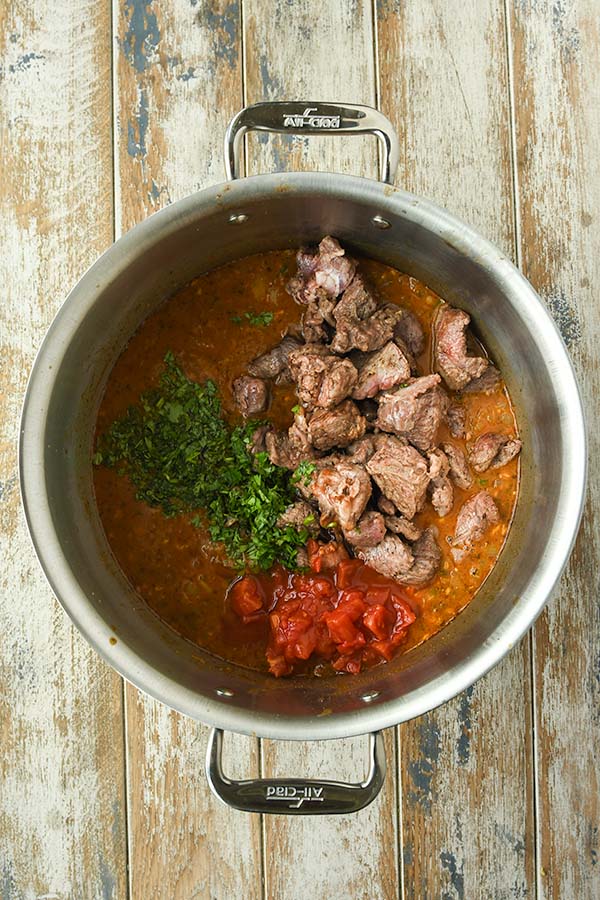 Step five is adding the beef back in with all of the broth, tomatoes and cilantro.