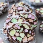 A stack of marshmallow church window cookies covered in coconut and a bowl of marshmallows in background.