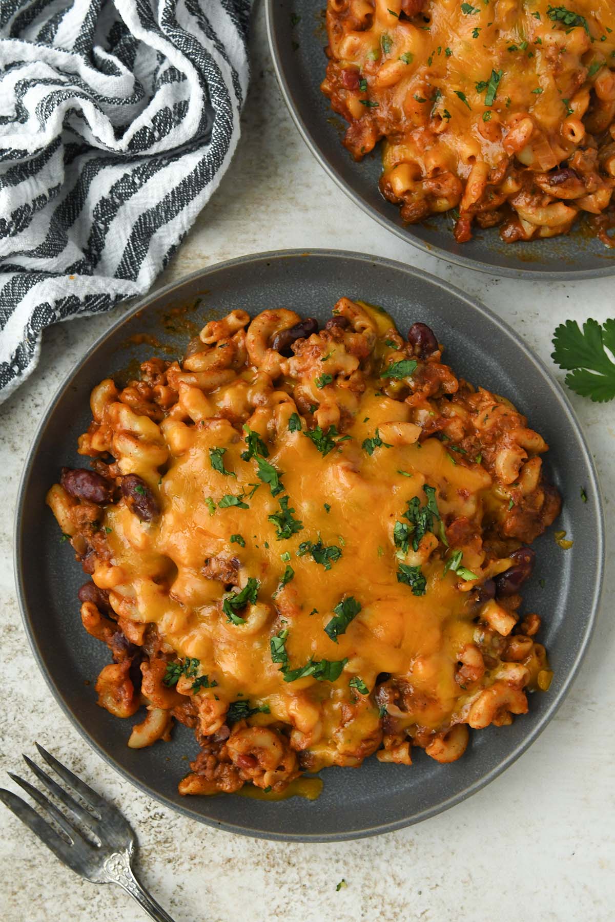 Above view of Chili macaroni and cheese sprinkled with cilantro with a fork.