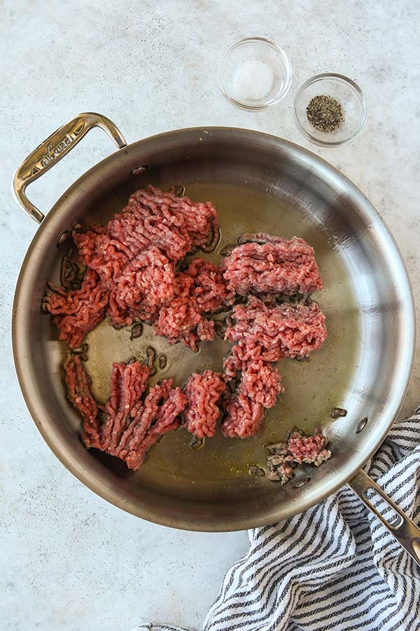 Step one is browning the ground beef in a pan.