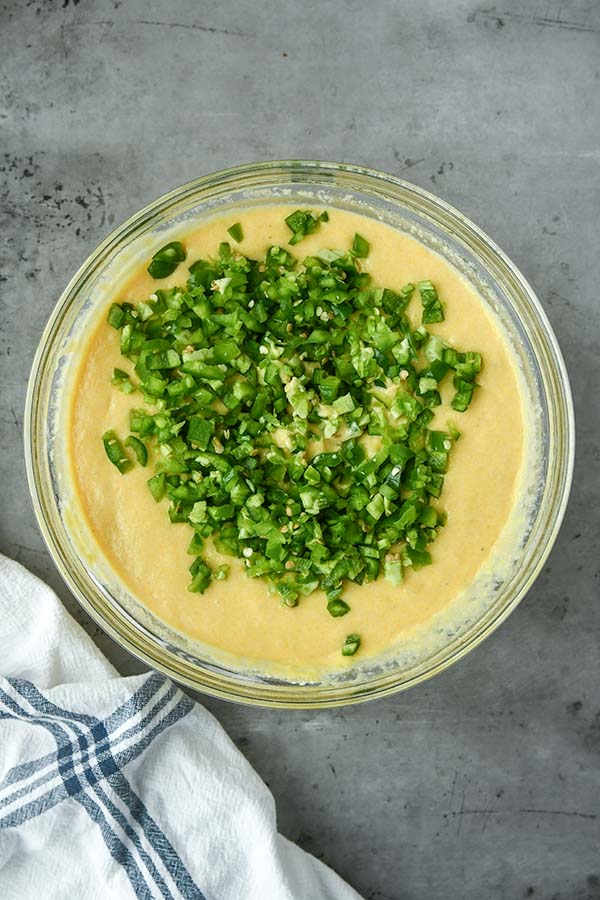 Step four is a adding in the chopped jalapeños to the wet batter.