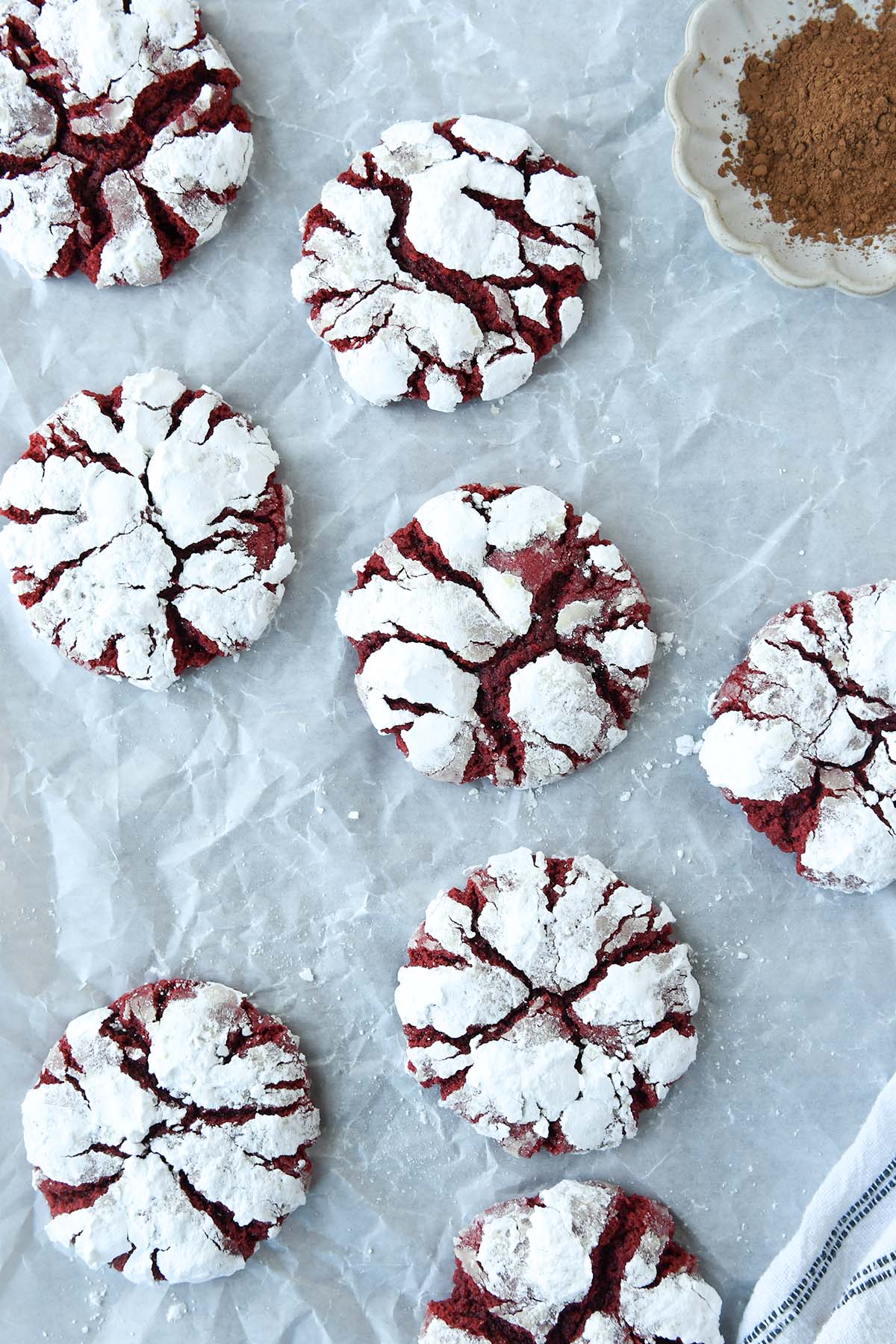 Above view of red velvet cookies with a small bowl of cocoa.