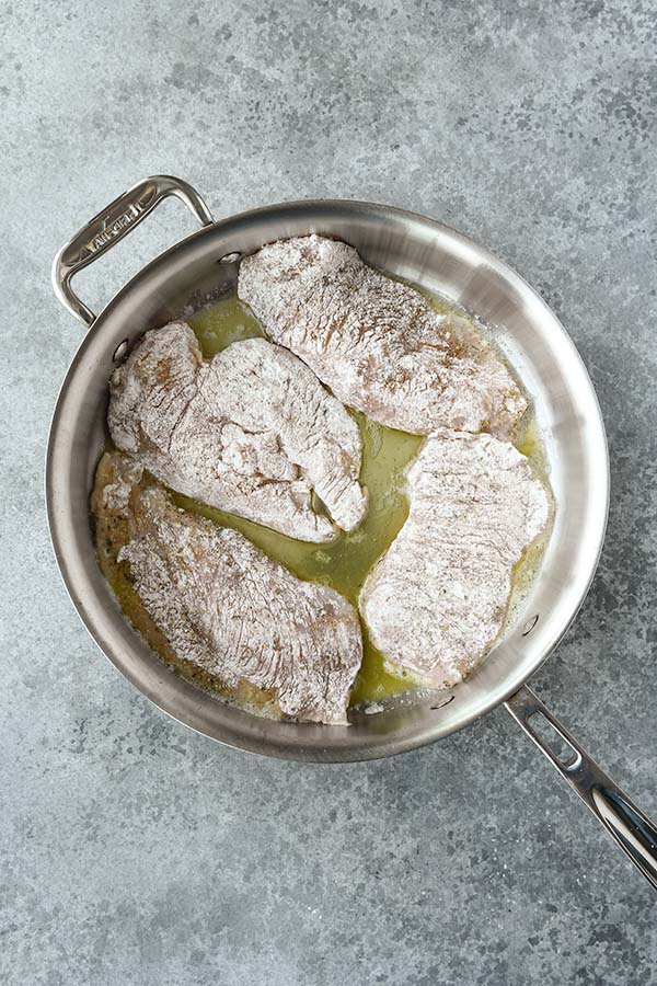 Step two is adding floured chicken to the hot oil and butter.