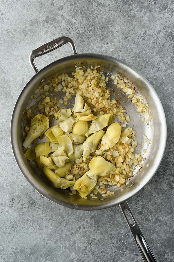 Step four is adding in the garlic and the artichoke hearts.