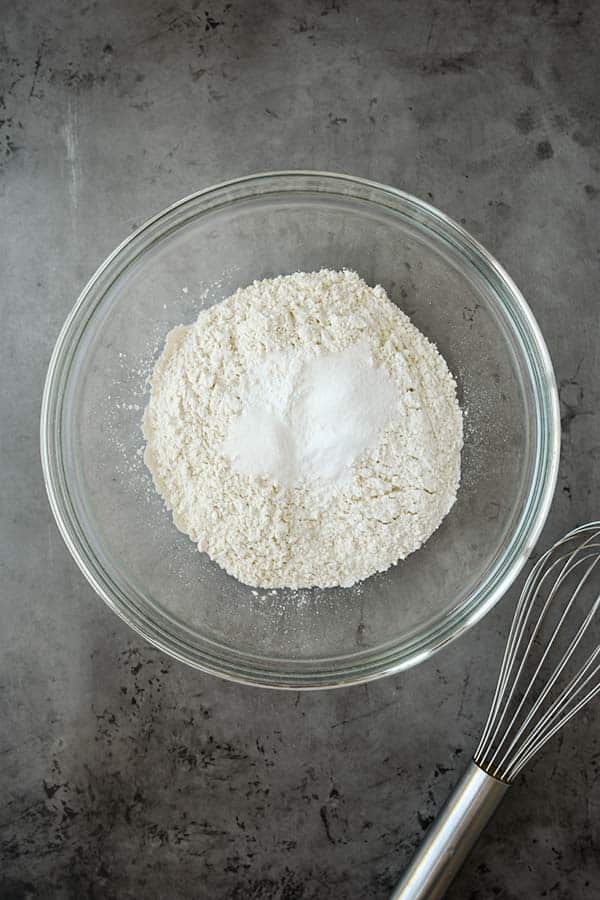 A bowl with all of the dry ingredients and a whisk.