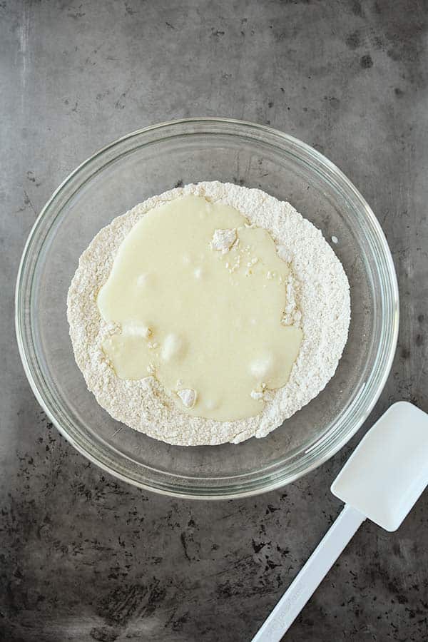 The buttermilk being stirred into the flour.