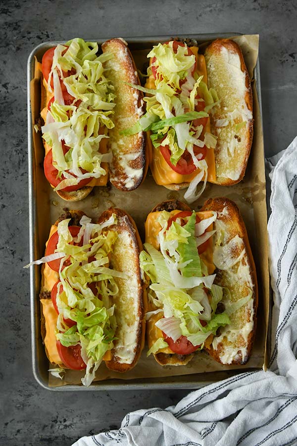 Step six is the adding the tomatoes and lettuce once the sandwiches come out of the oven.