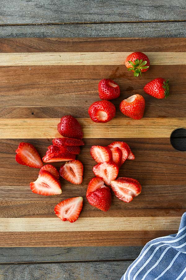 Step two is sliced strawberries on a cutting board.
