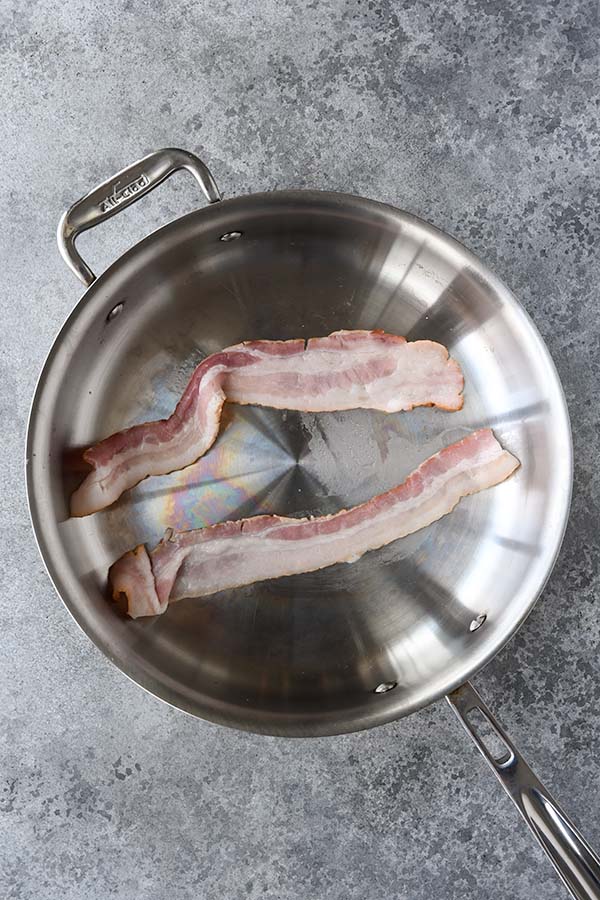 Step one is bacon cooking in a pan.