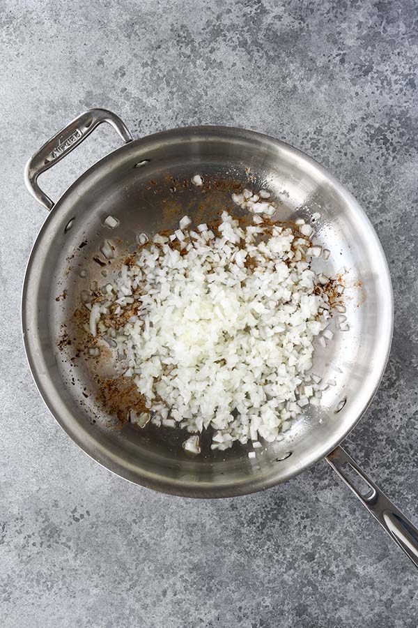 Step two is chopped onion added to the bacon grease in the pan.