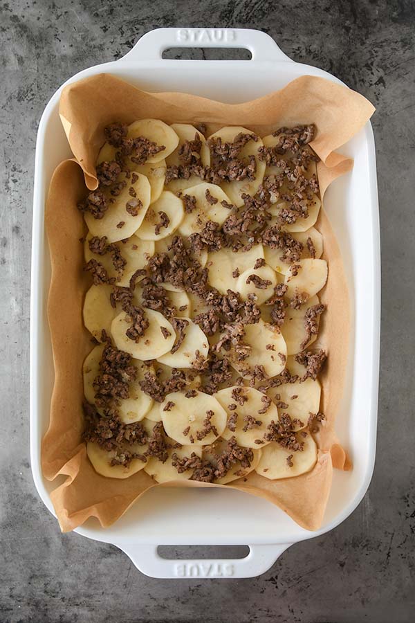Step five is ground beef added on top of the sliced potatoes.