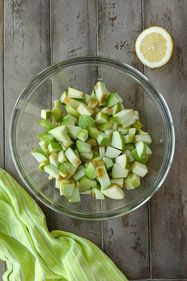Step two is cutting up the apples, putting them in a bowl, and stirring in the lemon juice.