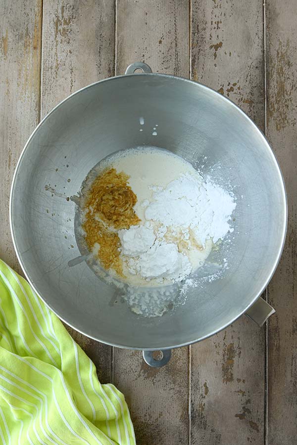 Step four is adding the heavy whipping cream, confectioners sugar, and vanilla into a metal bowl.