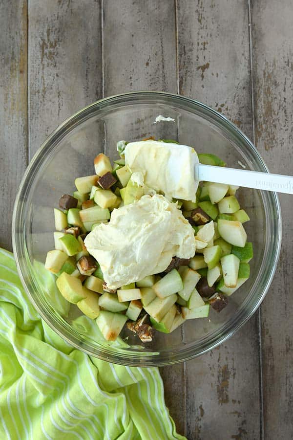 Step eight is gently combining the whipped cream mixture into the apples and candy bar.