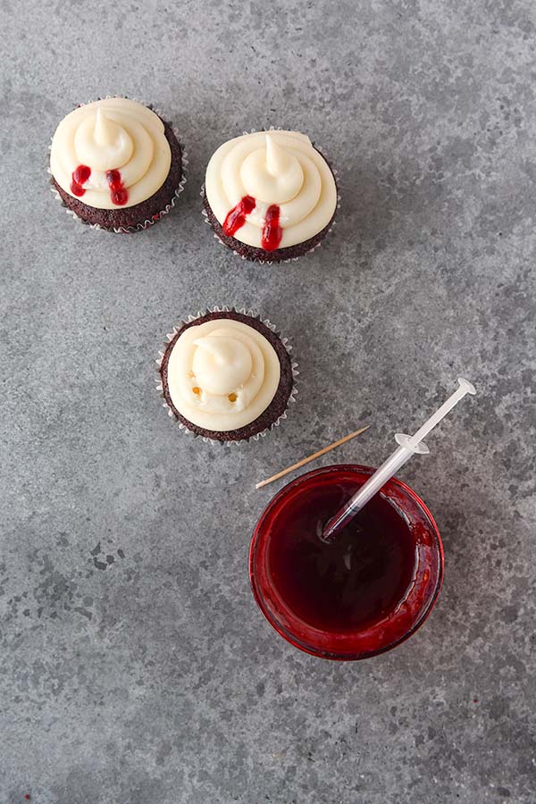 Step ten is frosting the cupcakes and adding raspberry jam to two puncture holes made in the frosting.