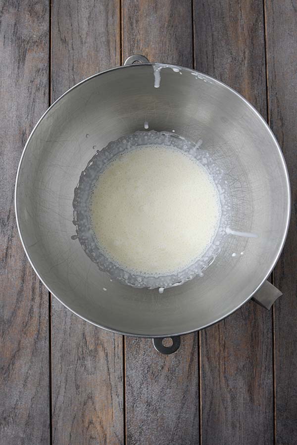 Step two is the heavy whipping cream added to a cold metal bowl of a stand mixer.