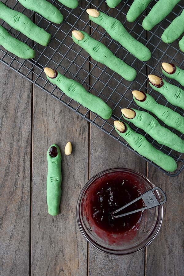 Step eight is the baked cookies on a cooling rack that get the almonds removed then add jam and replace the nails.